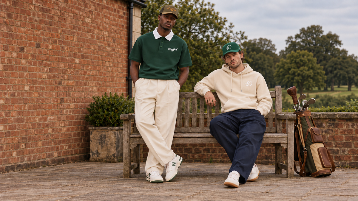 Golfers in Duffed dark green contrast-collar polo, apricot D hoodie and current Duffed caps outside the clubhouse